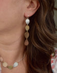 Model wearing handmade hydrangea petal ombré drop earrings in sterling silver brass bronze and copper, artisan botanical jewelry crafted in Vermont
