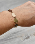 Model wearing handmade hydrangea petal ombré bracelet in sterling silver brass bronze and copper, artisan botanical nature jewelry crafted in Vermont