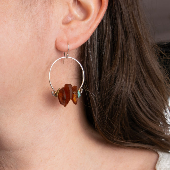 Model wearing handmade sterling silver amber and turquoise nugget hoop earrings with brass wire wrapping, artisan nature inspired gemstone jewelry handcrafted in Vermont