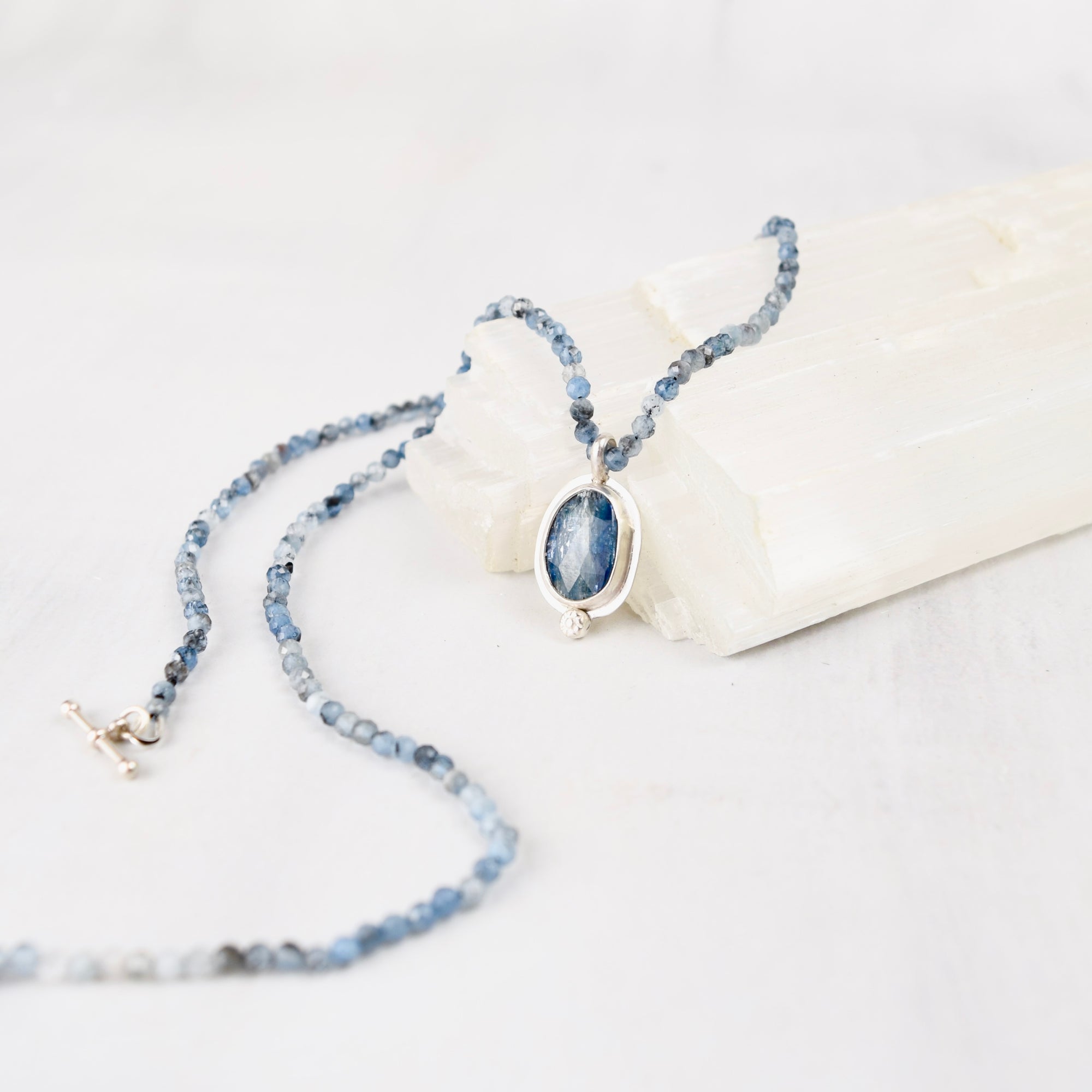 Close-up of faceted oval blue kyanite cabochon set in sterling silver