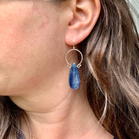 Model wearing handmade sterling silver blue kyanite drop hoop earrings with brass wire wrapping, artisan nature inspired gemstone jewelry handcrafted in Vermont
