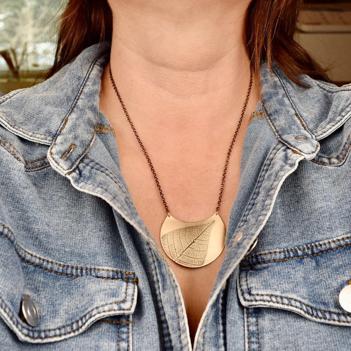 Model wearing large jeweler's brass crescent leaf necklace, handfabricated nature jewelry