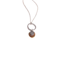 Flatlay of handmade gathered hydrangea petal pendant necklace in sterling silver, jeweler's brass and copper on hammered sterling silver circle, botanical jewelry crafted in Vermont