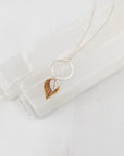 Graduated leaf necklace with sterling silver, copper, and brass leaves on white background