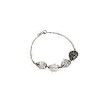 Overhead view of handmade sterling silver hydrangea petal impression bracelet, four connected petals with satin finish and patina, botanical jewelry crafted in Vermont