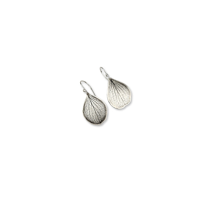 Overhead view of handmade sterling silver hydrangea petal impression dangle earrings with satin finish and patina, botanical jewelry crafted in Vermont