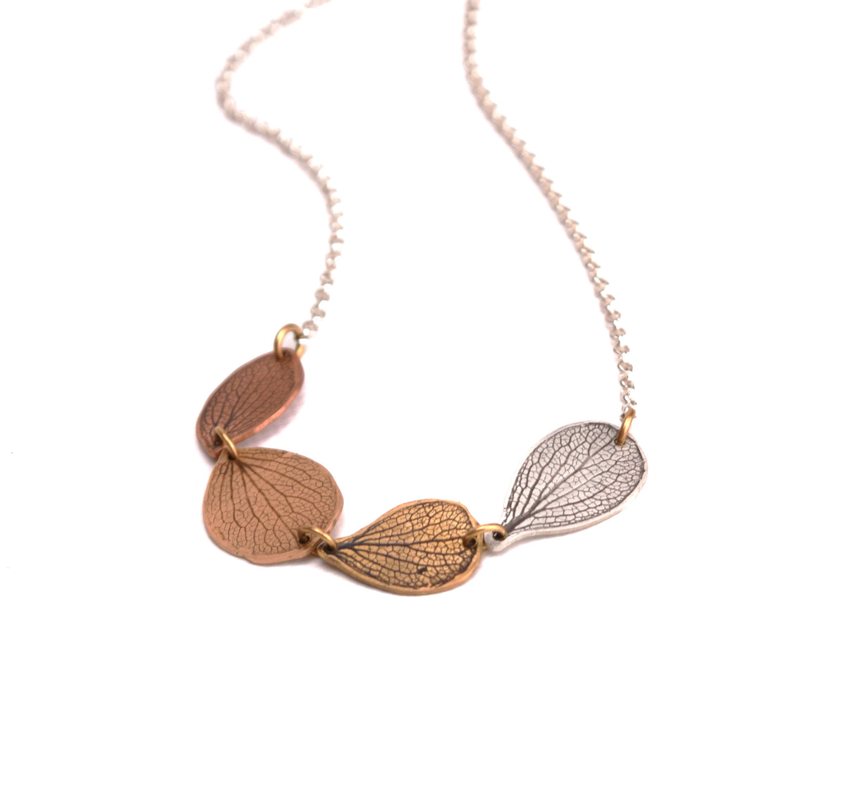 Overhead view of handmade hydrangea petal ombré choker necklace in sterling silver, jeweler's brass, bronze and copper, botanical jewelry crafted in Vermont