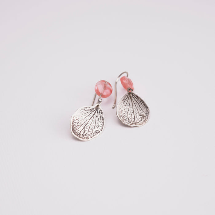 Overhead view of handmade sterling silver hydrangea petal and rose quartz dangle earrings, delicate botanical gemstone jewelry handcrafted in Vermont