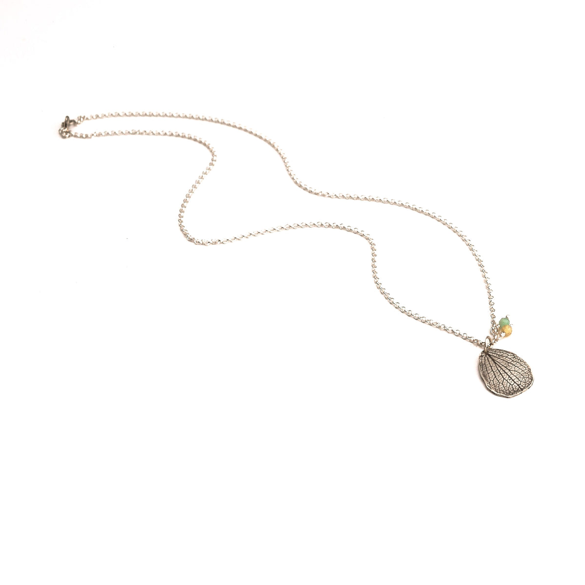 Full length overhead view of handmade sterling silver customizable hydrangea mother petal gemstone necklace on 18" chain, artisan botanical jewelry crafted in Vermont