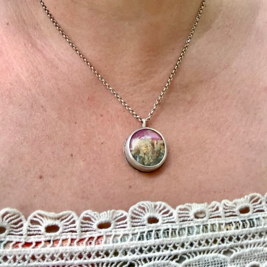 Model wearing one of a kind handmade sterling silver pink plume agate pendant necklace in hammered bezel setting, artisan gemstone jewelry crafted in Vermont