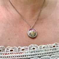 Model wearing one of a kind handmade sterling silver pink plume agate pendant necklace in hammered bezel setting, artisan gemstone jewelry crafted in Vermont