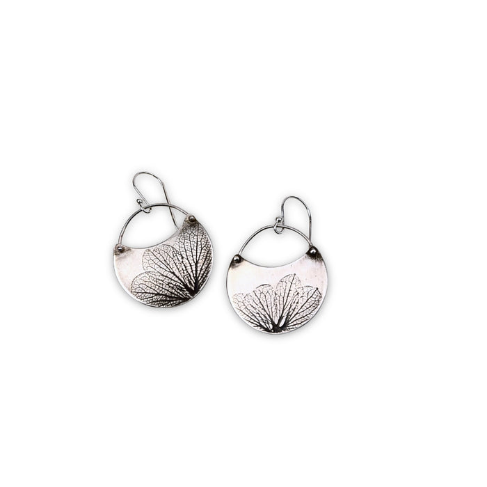 Overhead view of small handmade sterling silver hydrangea flower impression crescent dangle earrings, botanical jewelry crafted in Vermont
